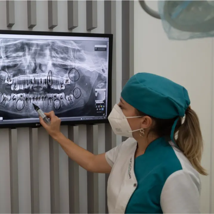 Odontóloga Marta Corrales en clínica dental en Ronda analizando radiografía de un paciente